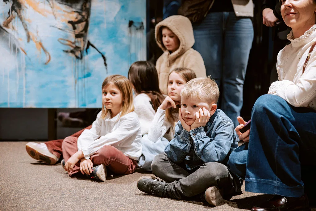 Kinder bestaunen die Kunstwerke bei der Vernissage